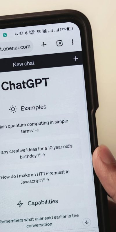 Webpage of ChatGPT, a prototype AI chatbot, is seen on the website of OpenAI, on a smartphone. Examples, capabilities, and limitations are shown.